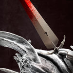 Close-up of a sword with a red blade and a dark background, featuring Claymore Teresa vs Priscilla statue base details